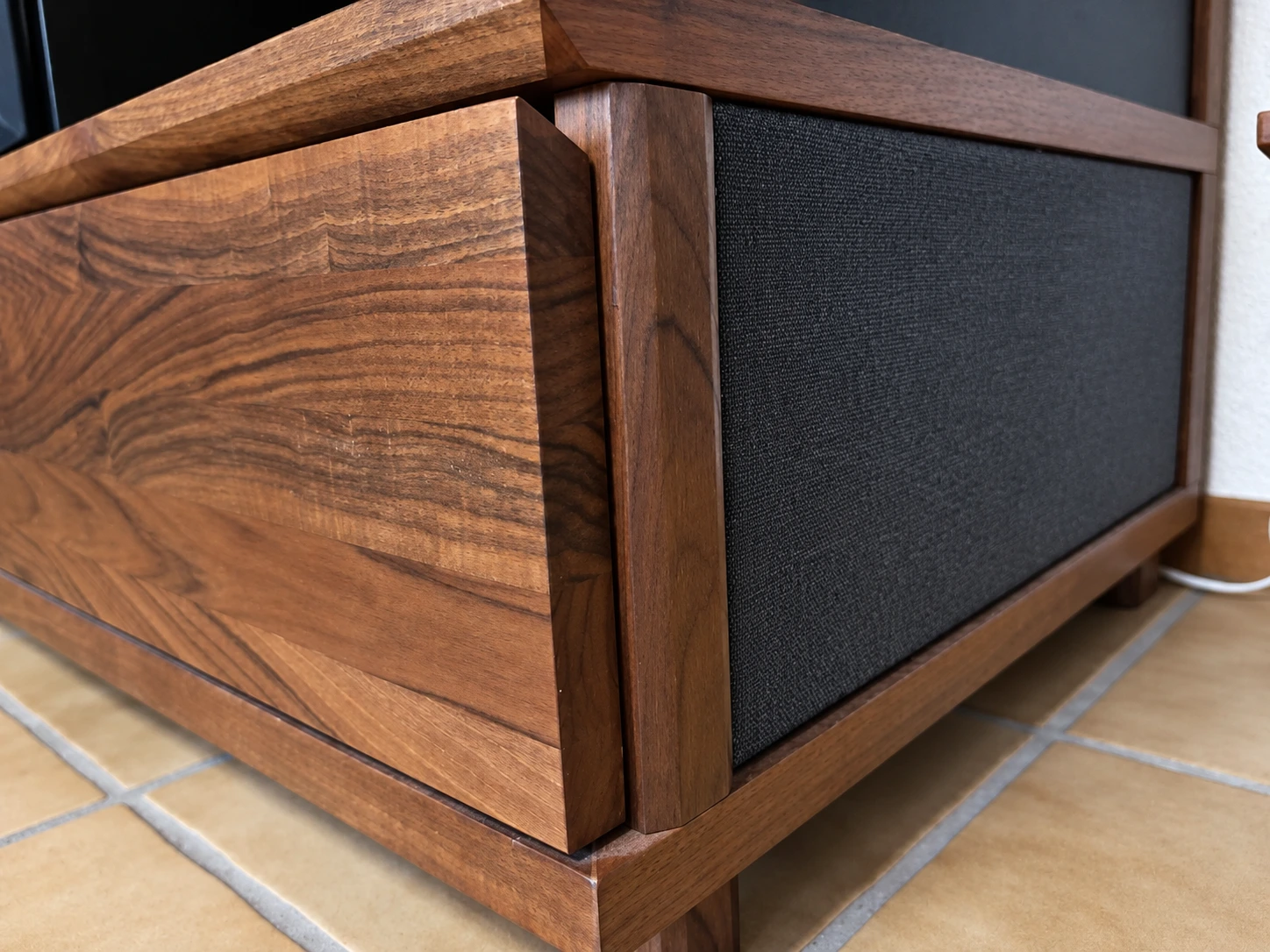 Detail des seFORM Schubladenmöbels: lebendige Holzmaserung, Holzrahmen und schwarze textile Seitenfläche